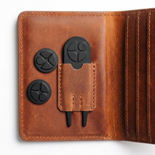 Close-up of Fairway Wallet with included golf accessories -- divot tool and ball markers.